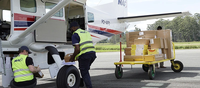 Two MAF workers removing cargo from the compartment under P2-AFD