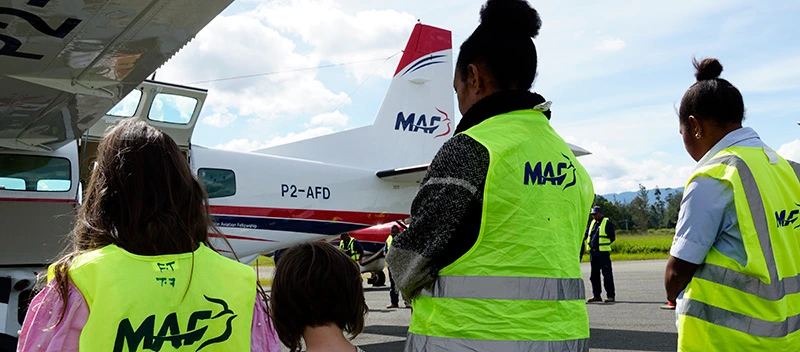 MAF workers in hi-vis standing in front of P2-AFD with the name in the background
